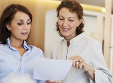 Deux femmes discutent en regardant un document - MACSF